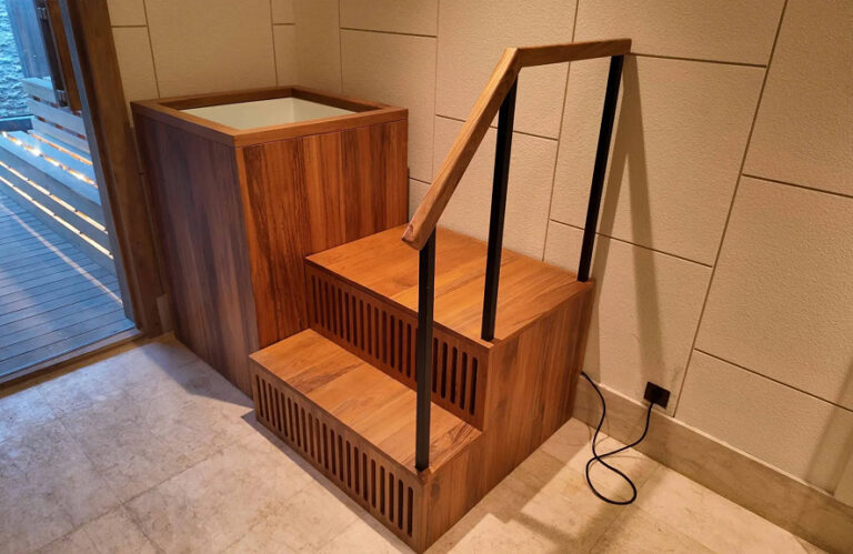 A handcrafted teak ice bath elegantly designed for cold therapy, featuring a stylish staircase and premium finish.