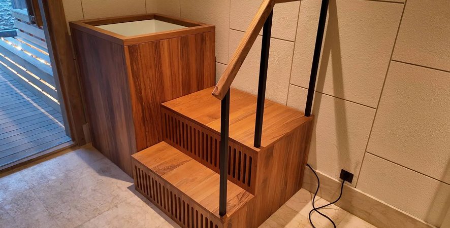 A handcrafted teak ice bath elegantly designed for cold therapy, featuring a stylish staircase and premium finish.