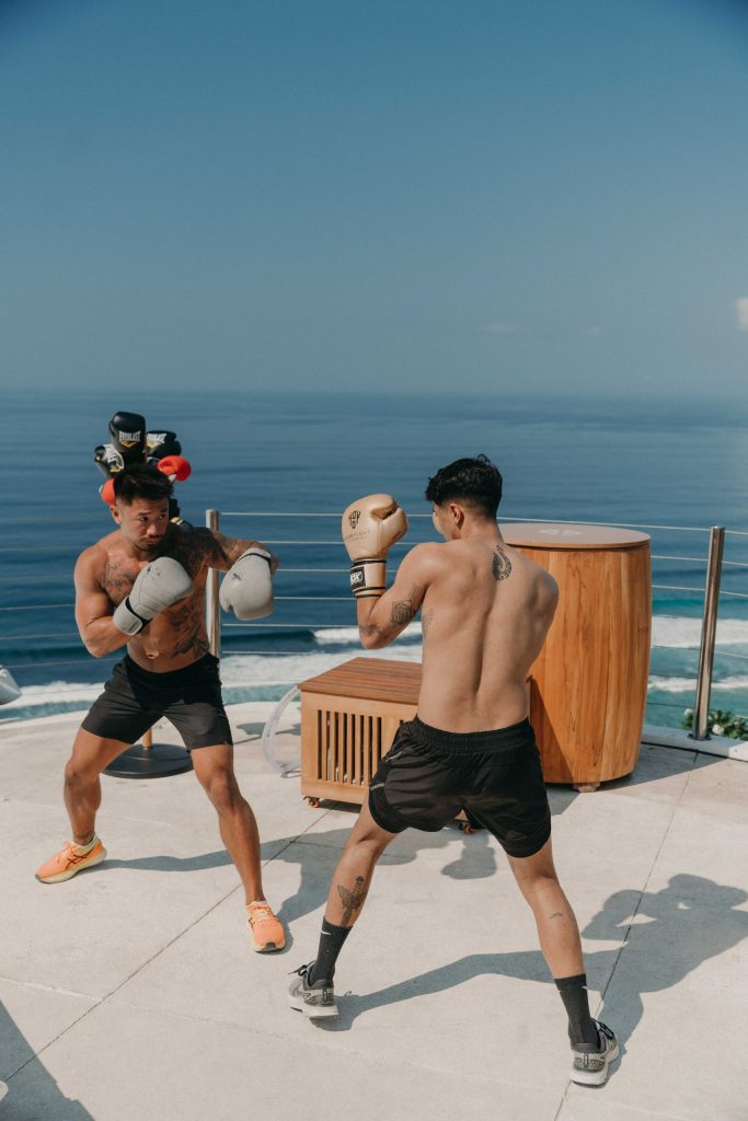 2 men boxing in front of a sea view