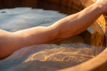 A man with a hand in an icebath.