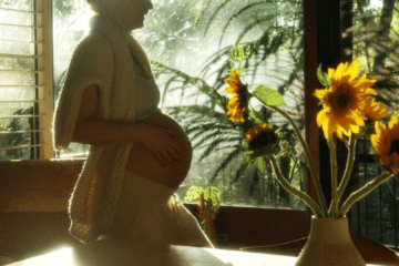 Quiet, intimate pregnancy-adjacent silhouette in warm morning light, reflecting cautious decision-making about cold water immersion