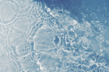 Macro view of a dark water surface where two ripple patterns collide, representing why ice bath studies can reach different conclusions.