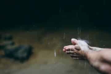 a man with his hands under a waterfall