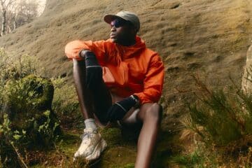 a runner, resting on the side of a hill in an orange jacket. Picture by Joey Bania