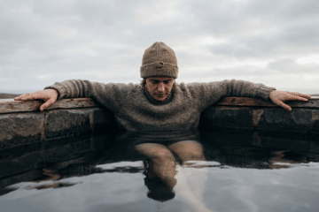 Person calmly immersed to the shoulders in a cold plunge pool, illustrating a goal-based ice bath protocol for temperature and duration.